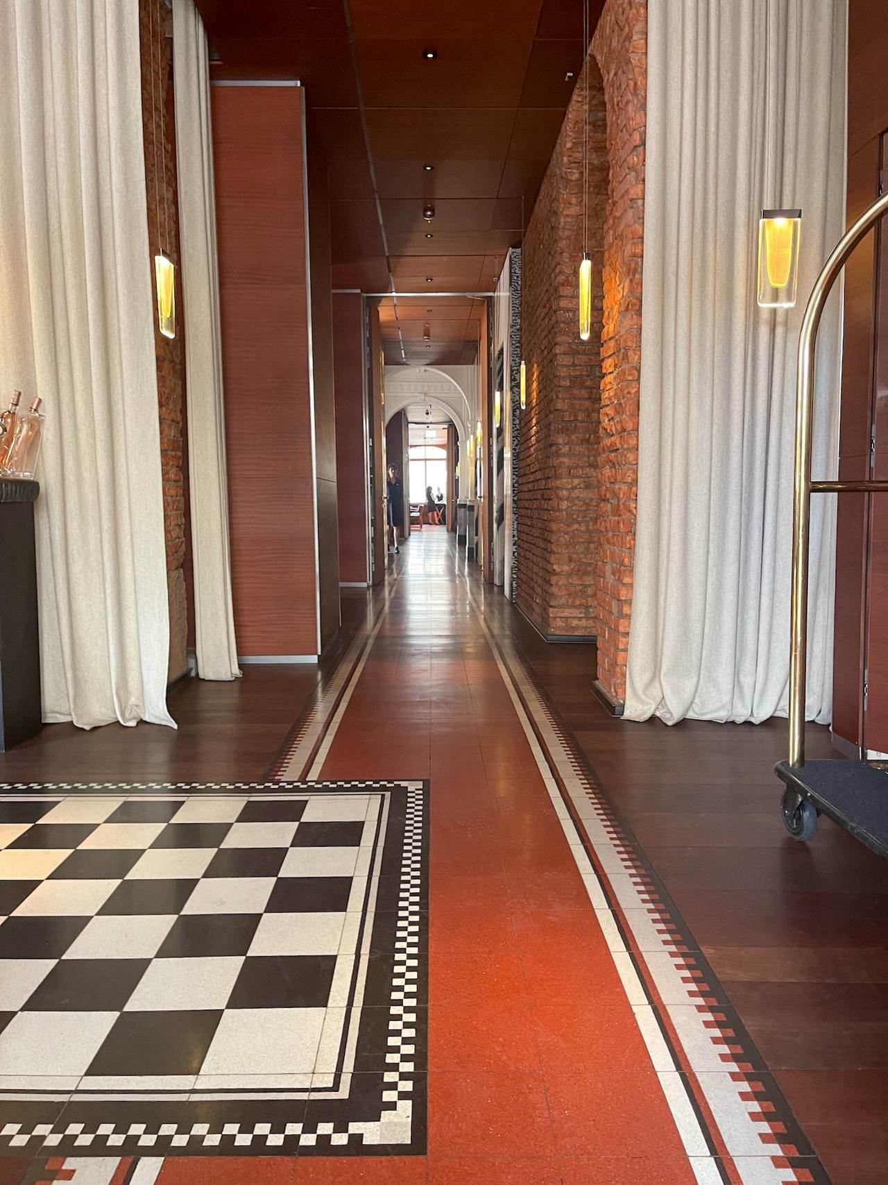 Hotelflur mit Terrazzoplatten in Rot und Schachbrettverlegung