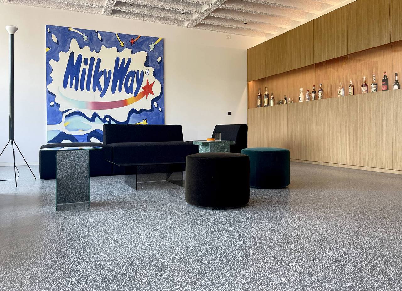 Terrazzofläsche mit goldenem Möbel, Sitzecke und Kunstwerk an der Wand 