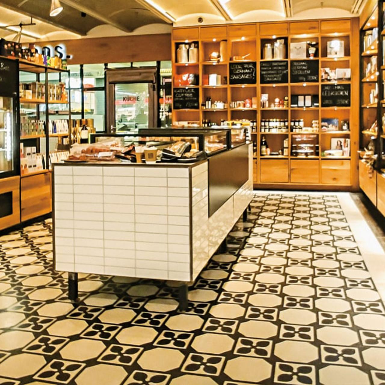 Diagonales Muster mit Terrazzofliesen mit Holzregalen im Flughafen Shop Diagonales Muster mit Terrazzofliesen mit Holzregalen im Flughafen Shop