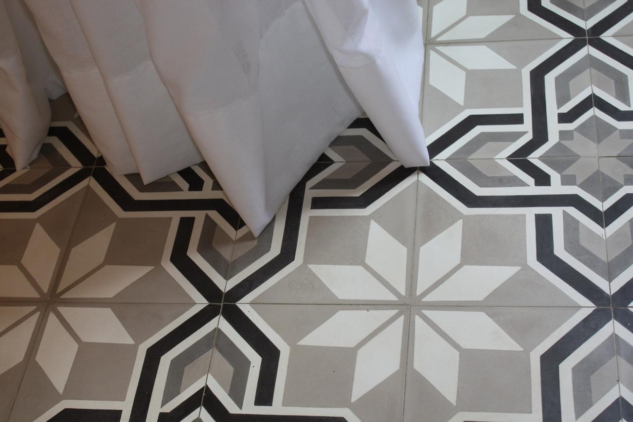 Klassische, mehrfarbige Zementfliese in Grautönen im Schlafzimmer Klassische, mehrfarbige Zementfliese in Grautönen im Schlafzimmer